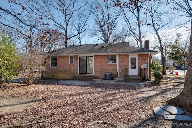 rear view of property featuring a patio, a chimney, crawl space, central air condition unit, and brick siding