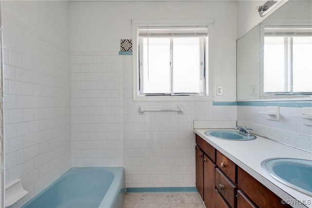 full bath featuring a sink, tile walls, double vanity, and tile patterned flooring