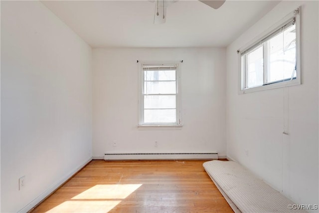 interior space with a baseboard radiator, light wood-style floors, and ceiling fan