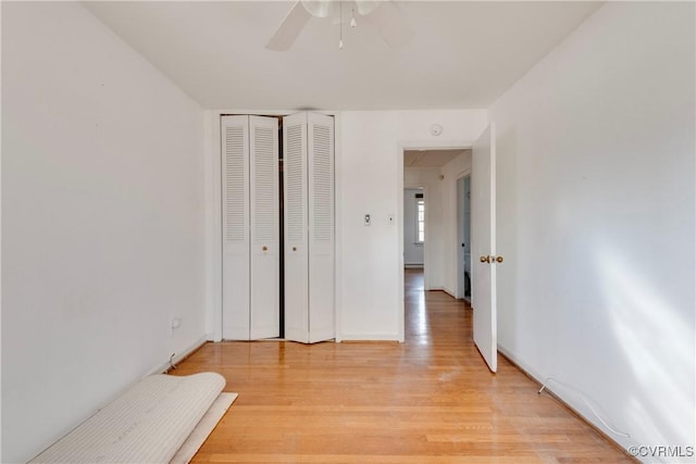 unfurnished bedroom with a closet, light wood-style flooring, and a ceiling fan