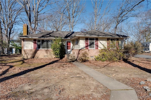 view of front of house with crawl space, a chimney, and brick siding