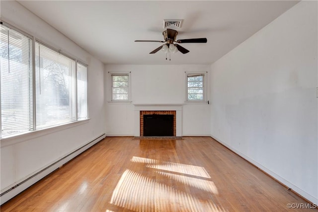 unfurnished living room with visible vents, wood finished floors, a baseboard radiator, a brick fireplace, and ceiling fan