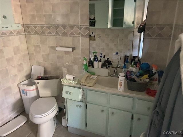 half bath featuring toilet, tasteful backsplash, tile walls, tile patterned flooring, and vanity