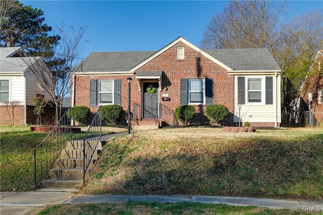 bungalow-style home featuring brick siding, roof with shingles, and a front lawn