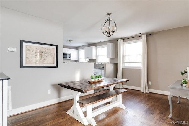 dining area featuring dark wood-style floors, a notable chandelier, visible vents, and baseboards