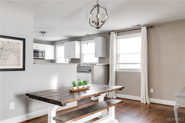 dining area with an inviting chandelier, dark wood-style floors, and baseboards