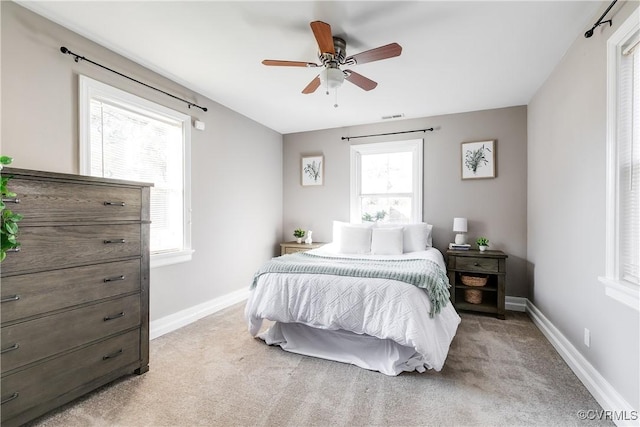 bedroom featuring ceiling fan, baseboards, visible vents, and light carpet