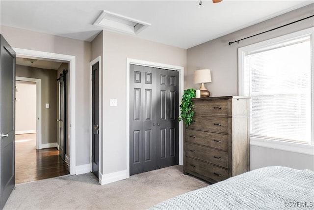 carpeted bedroom featuring a closet, baseboards, and attic access