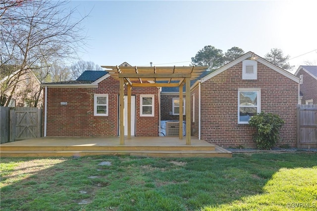 back of property featuring brick siding, a deck, and fence