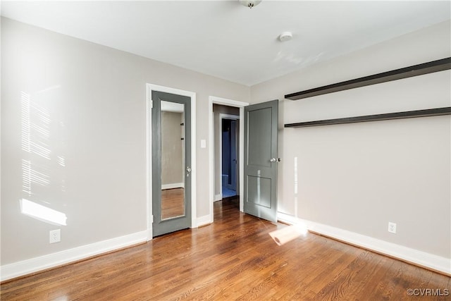 unfurnished bedroom featuring baseboards and wood finished floors