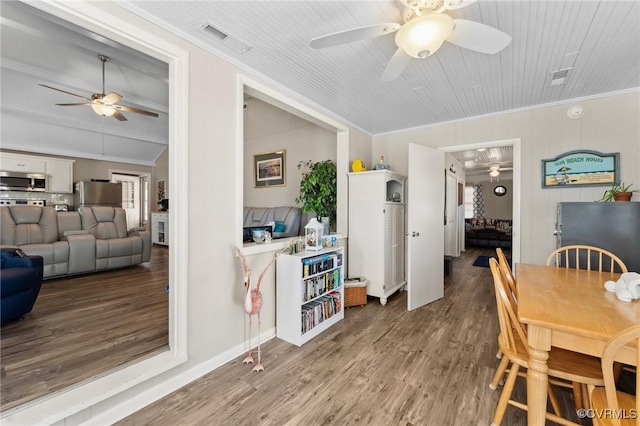 dining space with ceiling fan, visible vents, wood finished floors, and crown molding