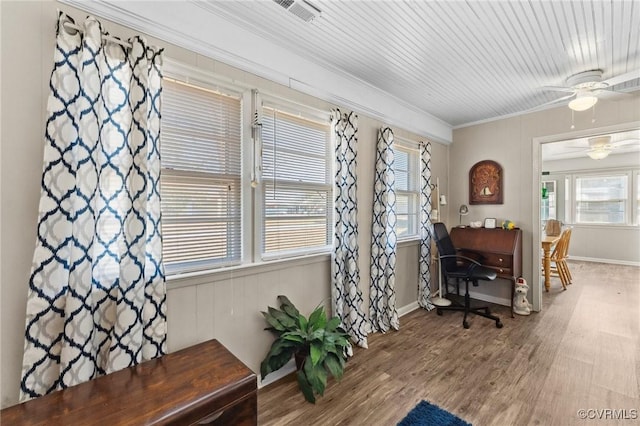 office space featuring visible vents, a ceiling fan, wood finished floors, crown molding, and baseboards