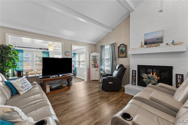 living room featuring a wealth of natural light, a fireplace, vaulted ceiling with beams, and wood finished floors