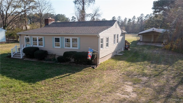 rear view of property featuring a detached carport, driveway, a chimney, and a yard