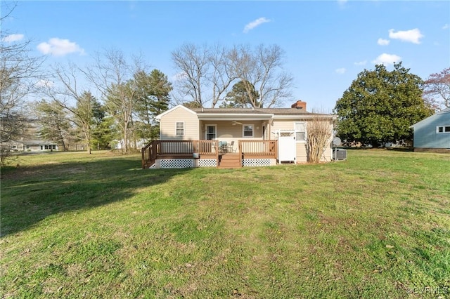 back of property with a lawn and a deck