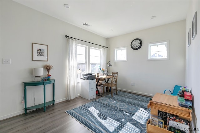 home office featuring visible vents, baseboards, and wood finished floors