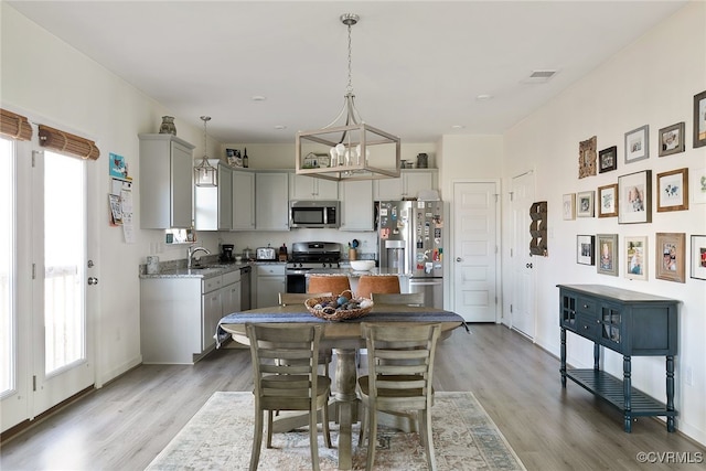 dining room featuring visible vents, baseboards, and light wood-style floors