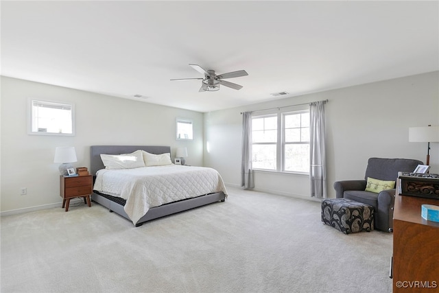 carpeted bedroom with visible vents, multiple windows, and baseboards