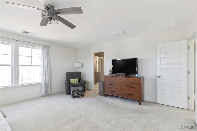 sitting room with visible vents, baseboards, light colored carpet, and a ceiling fan