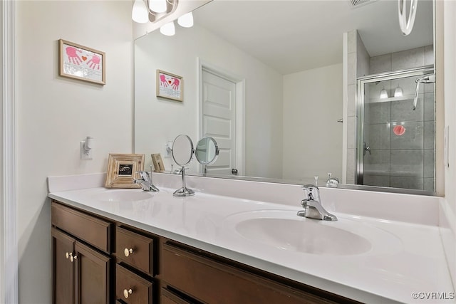 bathroom featuring a sink, visible vents, a stall shower, and double vanity