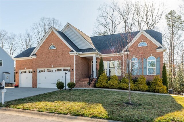 view of front of home with a front yard, concrete driveway, brick siding, and an attached garage