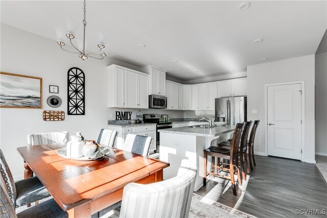 dining area featuring baseboards, a notable chandelier, and dark wood-style floors