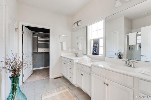 bathroom featuring visible vents, a shower stall, tile patterned flooring, baseboards, and vanity