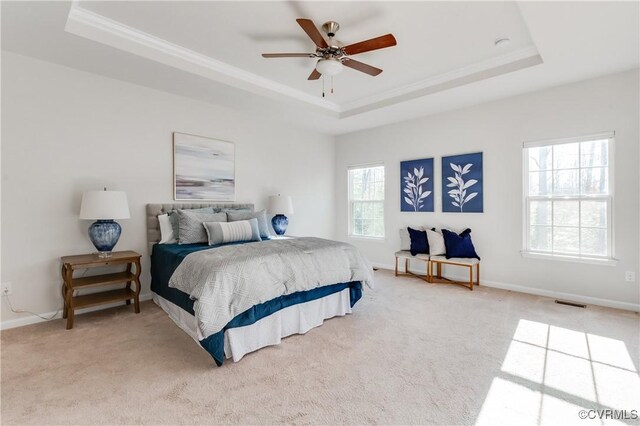 carpeted bedroom featuring crown molding, a raised ceiling, and baseboards