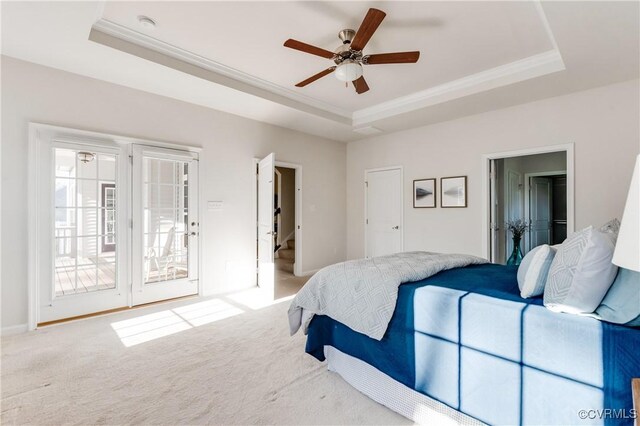 carpeted bedroom with a raised ceiling, access to outside, a ceiling fan, and ornamental molding