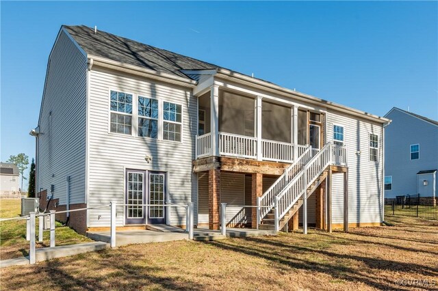 back of property featuring fence, stairs, a lawn, a sunroom, and a patio area