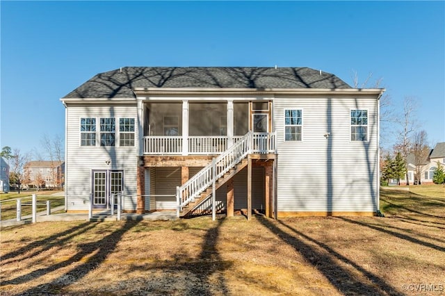 back of property with stairs, a yard, fence, and a sunroom