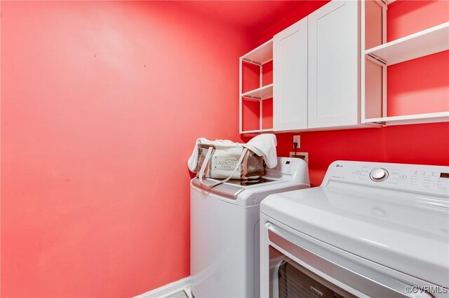 washroom featuring washing machine and clothes dryer and cabinet space