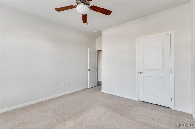 unfurnished bedroom with baseboards, light carpet, and a ceiling fan