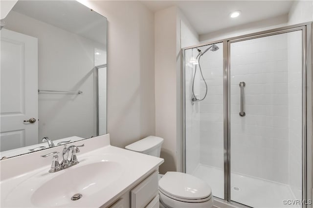 bathroom featuring vanity, toilet, and a stall shower