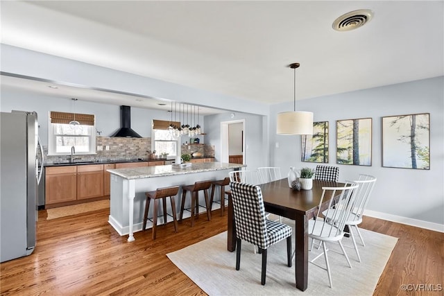 dining room with visible vents, baseboards, and light wood-style floors