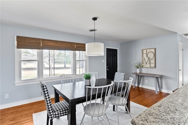 dining space with visible vents, baseboards, and light wood finished floors