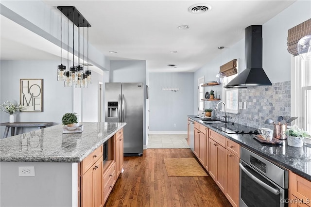 kitchen with visible vents, a sink, extractor fan, appliances with stainless steel finishes, and tasteful backsplash