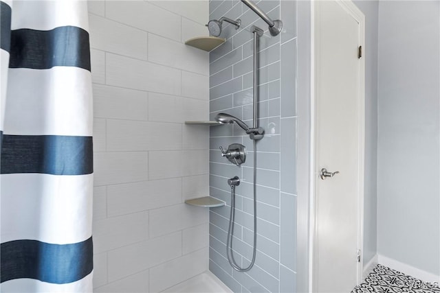 full bath featuring baseboards and a tile shower