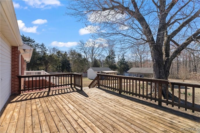 deck featuring a storage unit and an outbuilding