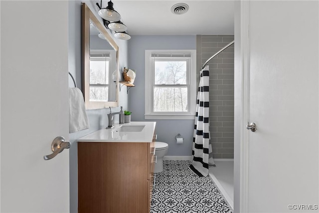 bathroom with vanity, a shower with curtain, visible vents, baseboards, and toilet