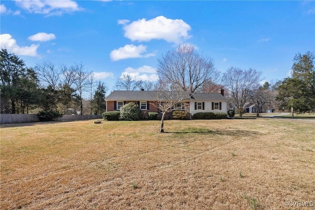 ranch-style house with a front yard and fence