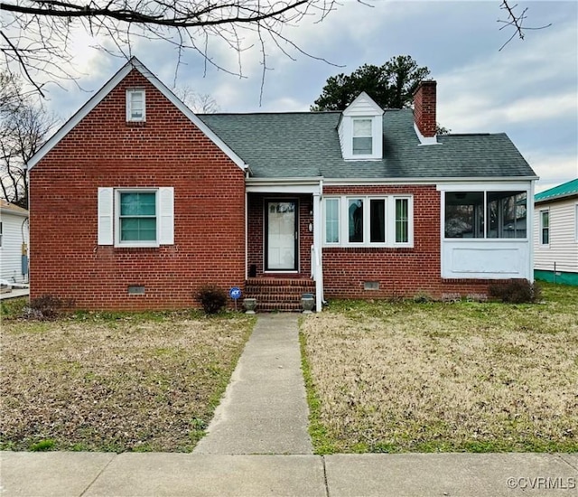 view of front of house with crawl space, a front lawn, brick siding, and a chimney