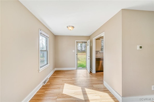 entryway with plenty of natural light, visible vents, baseboards, and light wood finished floors