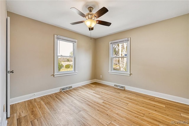 unfurnished room featuring light wood-type flooring, visible vents, baseboards, and a ceiling fan