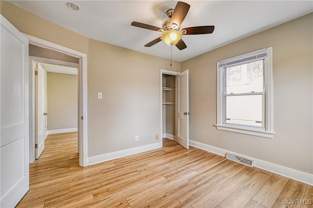 unfurnished bedroom featuring visible vents, baseboards, a closet, and light wood finished floors