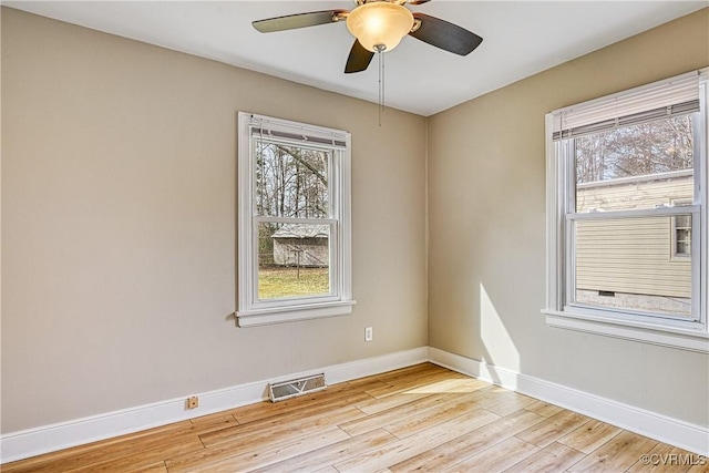 empty room with visible vents, baseboards, light wood-style flooring, and a ceiling fan