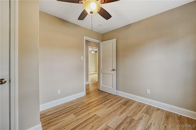 empty room featuring baseboards, light wood-type flooring, and ceiling fan