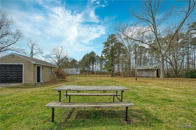 exterior space with a detached garage, a lawn, and an outdoor structure