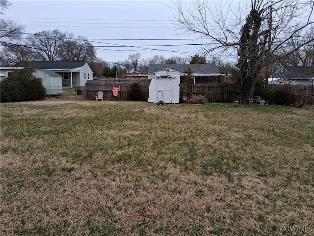 view of yard featuring a shed, an outdoor structure, and fence