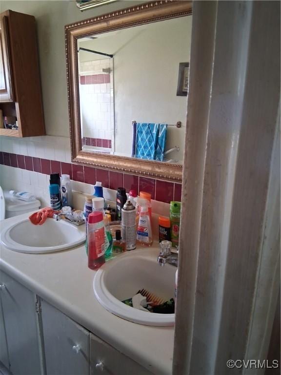 bathroom with a sink, tasteful backsplash, and double vanity